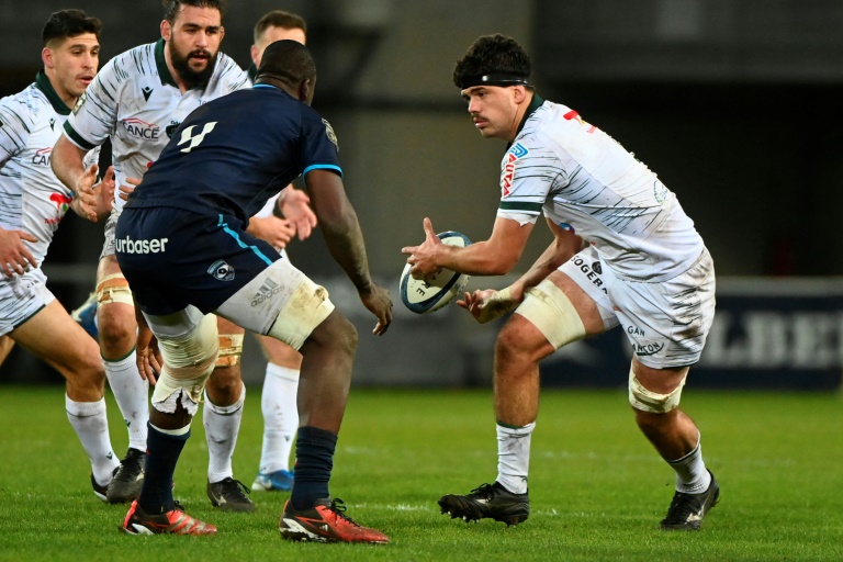 Le deuxième ligne français de Pau Hugo Auradou (d.) passe le ballon lors du match de Top 14 contre Montpellier, à Montpellier, le 23 novembre 2024