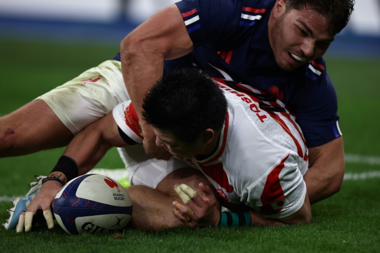 Le demi d'ouverture japonais Harumichi Tatekawa marque le premier essau du Japon malgré le plaquage du demi de mêlée français Antoine Dupont lors du match de la tournée d'automne entre la France et le Japon au Stade de France à Saint-Denis, le 9 novembre 2024