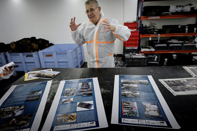 Stéphane Deschamps, chef du service régional d'archéologie de la Drac, s'adresse aux journalistes à côté de vestiges de la cathédrale Notre-Dame de Paris stockés dans un entrepôt en région parisienne, le 21 novembre 2024