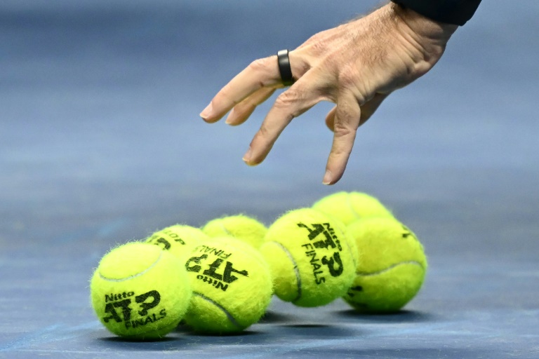 Un officiel ramasse des balles utilisées lors d'un match des Masters ATP le 11 novembre 2024 à Turin