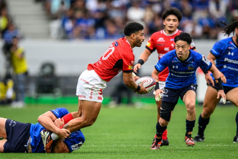 Le demi de mêlée néo-zélandais des Brave Lupus de Tokyo Richie Mo'unga (c.) passe le ballon lors de la finale de la Japan Rugby League One contre les Saitama Wild Knights, au stade national de Tokyo, le 26 mai 2024