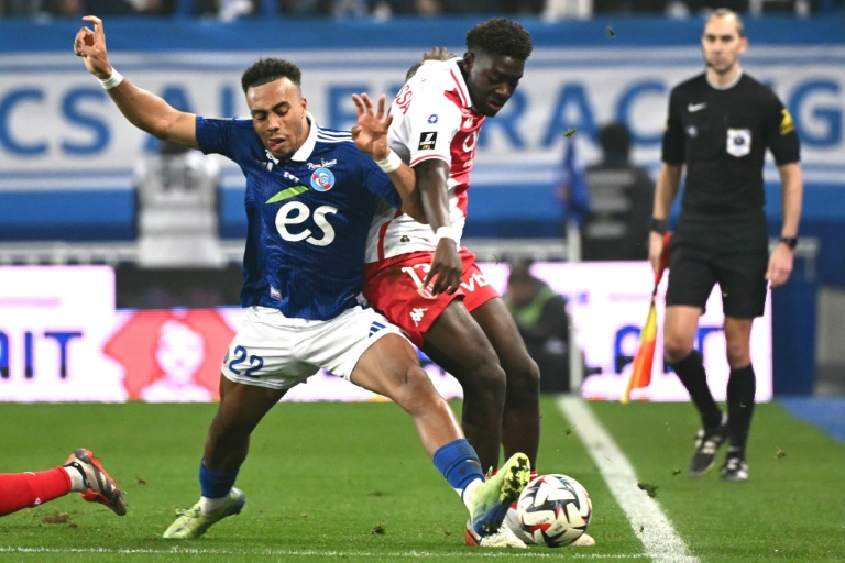 Le défenseur de Strasbourg Guéla Doué (à gauche), auteur du seul but de son équipe face à Monaco, se bat pour le ballon avec le défenseur de Monaco Christian Mawissa (C) lors de la 11e journée de Ligue 1, à Strasbourg, le 9 novembre 2024