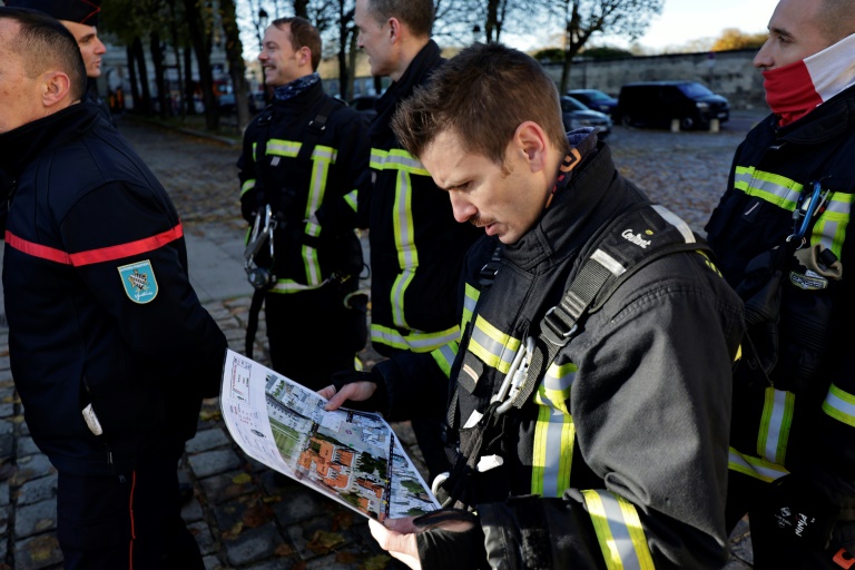 Des pompiers regardent un plan lors d'un exercice d'incendie grandeur nature à la cathédrale Saint-Louis de Versailles, le 20 novembre 2024