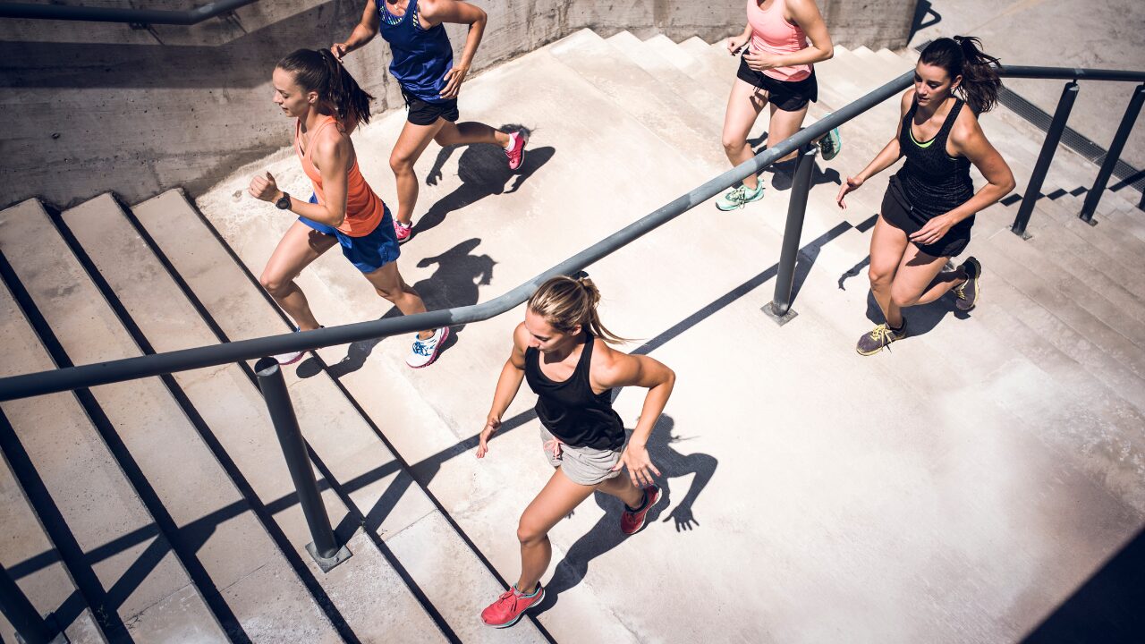 Un petit groupe de femmes pratiquent de la course à pied. Sans s'arrêter de trottiner, elles grimpent les marches d'un escalier