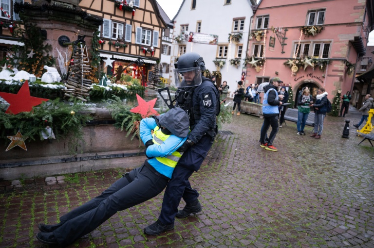 Un gendarme porte une volontaire jouant le rôle d'une victime pendant un exercice simulant une attaque terroriste, le 28 novembre 2024 à Eguisheim, dans le Haut-Rhin