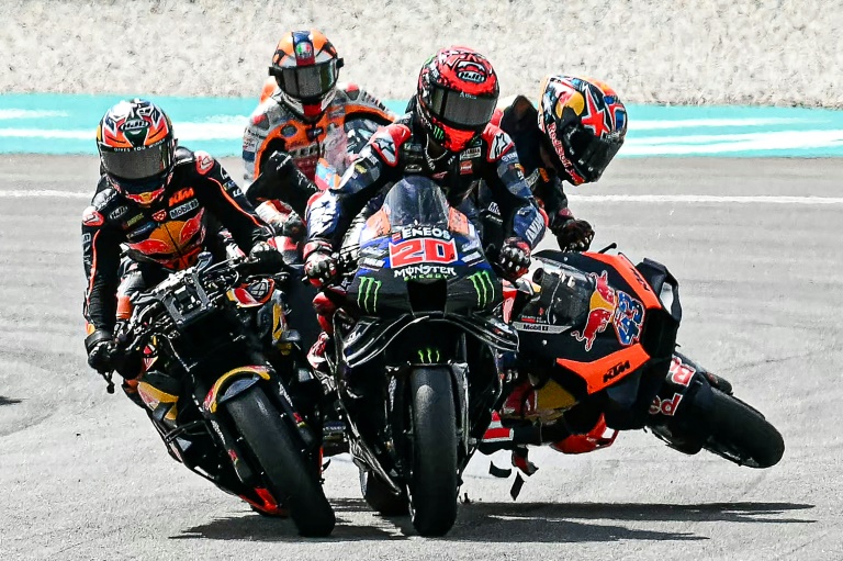 Le pilote australien de KTM  Jack Miller (d.) entre en collision avec le pilote français de Yamaha Fabio Quartararo (c.) et le pilote sud-africain de KTM Brad Binder (g.) au départ du Grand Prix de Malaisie de MotoGP, sur le circuit international de Sepang, le 3 novembre 2024