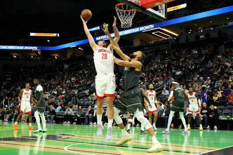 Alperen Sengun (g) face à Rudy Gobert lors du match de NBA entre les Houston Rockets et les Minnesota Timberwolves, le 26 novembre 2024 à Minneapolis