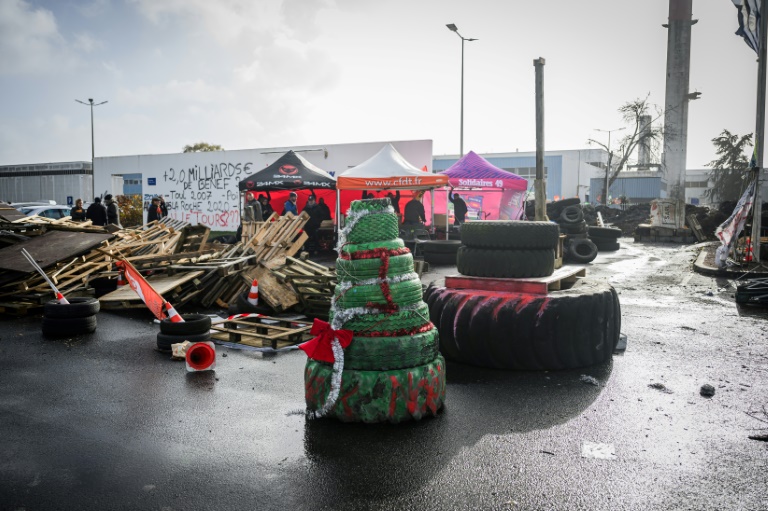 Des pneus peints en vert et empilés en forme de sapin de Noël devant l'entrée de l'usine Michelin à Cholet, le 21 novembre 2024 en Maine-et-Loire