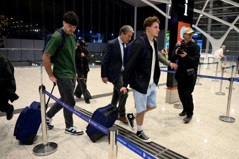 Les joueurs de rugby français Hugo Auradou (gauche) et Oscar Jégou (2e à partir de la droite) se dirigent vers leur vol à destination de la France, le 3 septembre 2024 à l'aéroport international d'Ezeiza en Argentine