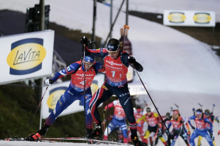 Le Norvégien Sturla Holm Laegreid (à droite) à la lutte avec Fabien Claude durant le relais masculin de coupe du monde de biathlon dimanche à  Kontiolahti, en Finlande.