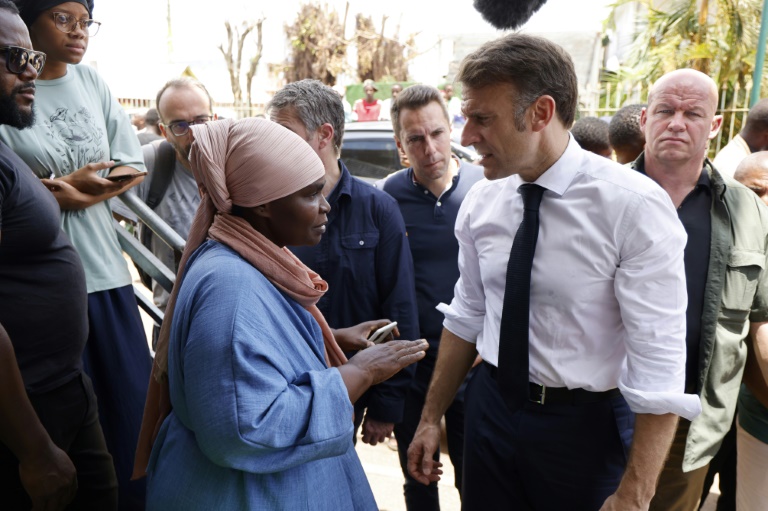 Le président Emmanuel Macron s'entretient avec des habitants lors de sa visite dans un quartier de Tsingoni, à Mayotte, après le passage du cyclone Chido sur l'archipel, le 20 décembre 2024