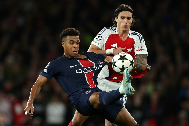 Le milieu du PSG Désiré Doué (gauche) au duel avec le défenseur italien d'Arsenal Riccardo Calafiori, en Ligue des champions, le 1er octobre 2024 à Londres