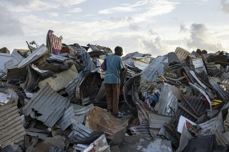 Dans une décharge de Mamoudzou, un homme cherche des tôles pour reconstruire sa maison le 28 décembre 2024