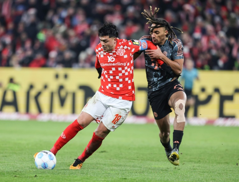 Le joueur de Mayence Tim Breithaupt (en rouge) aux prises avec le défenseur français du Bayern Sacha Boey pendant le match de Bundesliga entre les deux équipes samedi à Mayence.