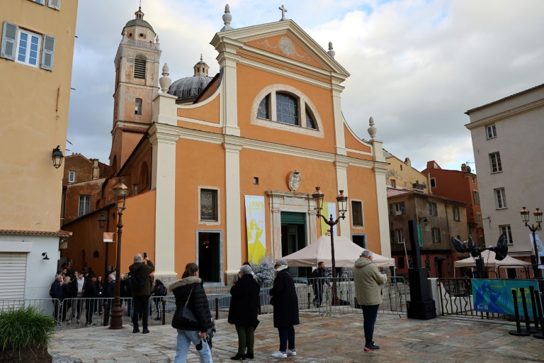 Des piétons devant la cathédrale d'Ajaccio en Corse la veille de la visite du pape François sur l'île, le 14 décembre 2024