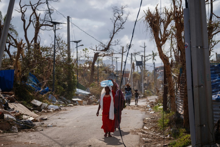 Une habitante porte un bidon d'eau à Pamandzi, après le passage du cyclone Chido à Mayotte, le 17 décembre 2024