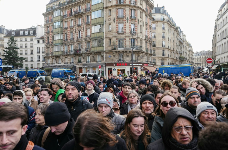 Des personnes attendent pour entrer à l'intérieur du périmètre de sécurité autour de la cathédrale Notre-Dame de Paris, avant sa réouverture officielle, le 7 décembre 2024 à Paris