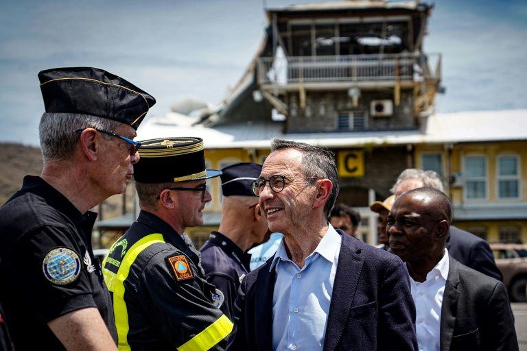 Le ministre de l'Intérieur démissionnaire Bruno Retailleau (C) serre la main de fonctionnaires à son arrivée sur l'archipel français de Mayotte dans l'océan Indien, le 16 décembre 2024, à la suite du passage du cyclone Chido