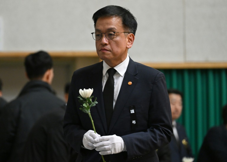 Le ministre sud-coréen des finances et président par intérim Choi Sang-mok dépose une fleur sur l'autel commémoratif des victimes de l'accident d'avion de Jeju Air, à Muan, le 30 décembre 2024