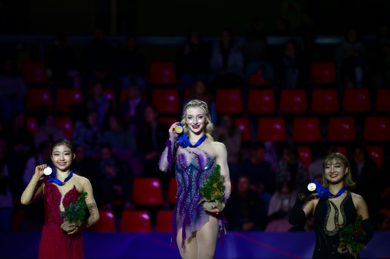 L'Américaine Amber Glenn (C) célèbre sa victoire lors du Grand Prix de Grenoble devant les Japonaises Mone Chiba (G) et Kaori Sakamoto, le 7 décembre 2024