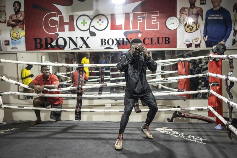 Un boxeur s'entraîne sur le ring de la salle Bronx Boxing Gym du quartier de Jamestown, le 11 décembre 2024 à Accra