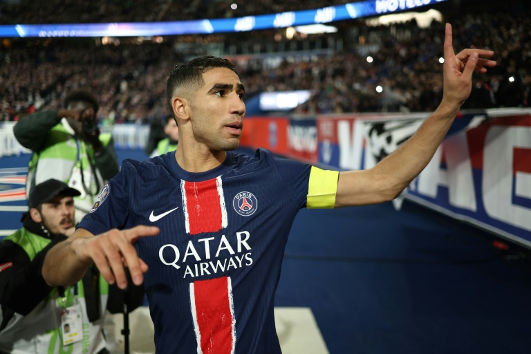 Le capitaine du Paris Saint-Germain Achraf Hakimi demande aux supporters de cesser des chants insultants lors du match de championnat de France de Ligue 1 contre l'Olympique lyonnais au Parc des princes le 15 décembre 2024.