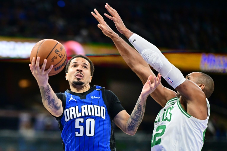 Cole Anthony (g.), le meneur du Magic d'Orlando, se dirige vers le panier face à Al Horford, l'ailier fort des Celtics de Boston, lors d'un match de NBA, à Orlando, le 23 décembre 2024