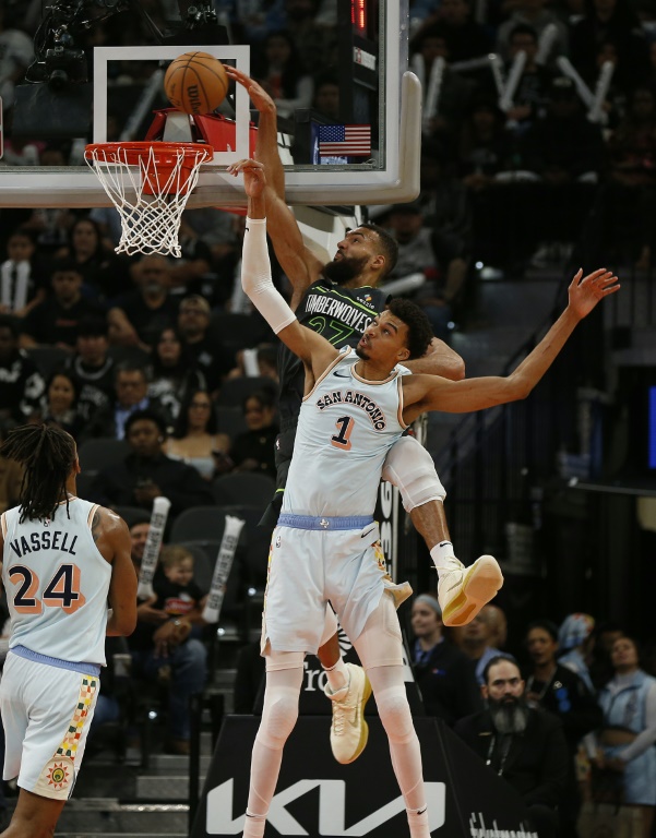 Les Français Rudy Gobert (#27), des Minnesota Timberwolves, et Victor Wembanyama (#1), des Spurs, à la lutte lors d'un match de saison régulière de NBA, le 15 décembre 2024 à San Antonio