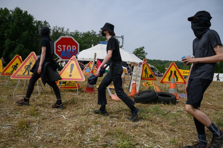 Des manifestants masqués près d'un campement de militants protestant contre le projet d'autoroute A69 Toulouse-Castres, près de Puylaurens (Tarn), le 8 juin 2024