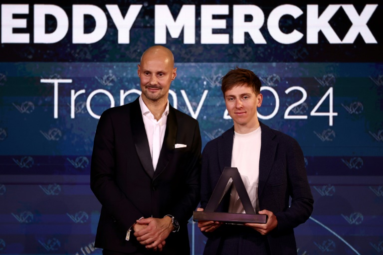 Le Slovène Tadej Pogacar reçoit le trophée Eddy Merckx des mains de l'ex-sprinteur belge Tom Boonen à Paris le 6 décembre 2024