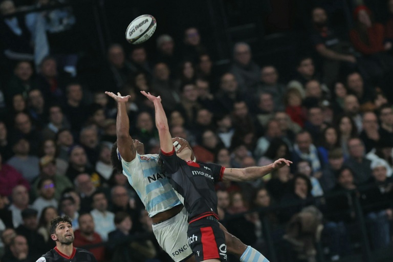 L'ailier fidjien du Racing 92 Vinaya met la main sur le visage de l'arrière géorgien de Lyon Davit Niniashvili en sautant en touche, dimanche en top-14 à la Défense Arena à Paris.