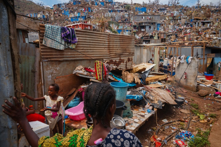 Une habitante et sa fille au milieu des débris des maisons détruites par le passage du cyclone Chido à Mayotte, dans le bidonville de Kawéni, le 20 décembre 2024 à Mamoudzou