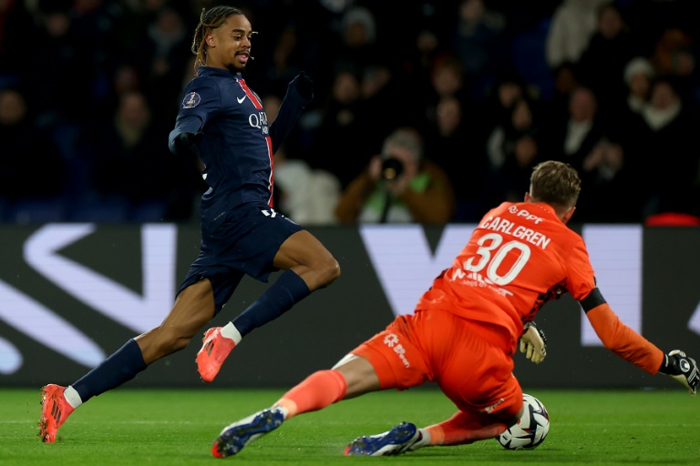 Le gardien de but suédois du FC Nantes, Patrik Carlgren (à droite), fait un arrêt devant l'attaquant français du Paris Saint-Germain, Bradley Barcola (à gauche), lors du match de L1 entre le PSG et le FCNA au stade du Parc des Princes, à Paris, le 30 novembre 2024