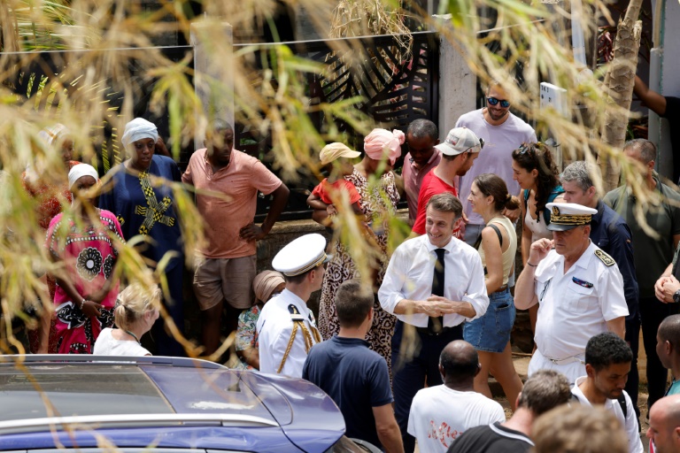 Emmanuel Macron avec des habitants lors de sa visite d'un quartier privé d'électricité et d'eau après le passage du cyclone Chido à Tsingoni, à Mayotte, le 20 décembre 2024