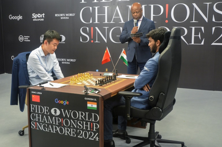 Le grand maître d'échecs chinois Ding Liren (à gauche) et le grand maître indien Gukesh Dommaraju (à droite) se préparent à disputer la partie finale du championnat du monde d'échecs 2024, à Singapour, le 12 décembre 2024