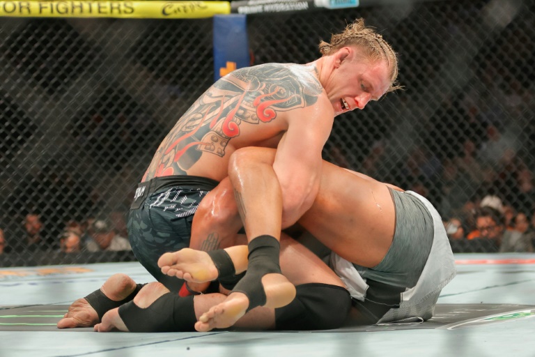 Le Russe Alexander Volkov lutte contre le Français Ciryl Gane au troisième round de leur combat à l'UFC 310, à Las Vegas, le 7 décembre 2024