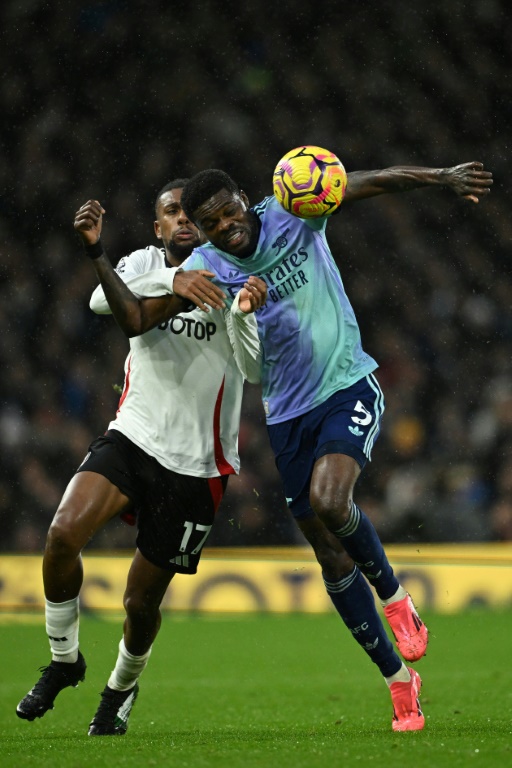 Le milieu de Fulham Alex Iwobi (G) et celui d'Arsenal Thomas Partey (D) à la lutte pour le ballon, à Londres, le 8 décembre 2024