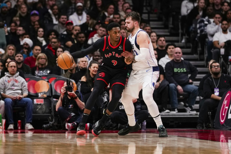 RJ Barrett, l'arrière canadien des Toronto Raptors, tente de passer Luka Doncic, le meneur slovène des Dallas Mavericks, à Toronto, le 7 décembre 2024