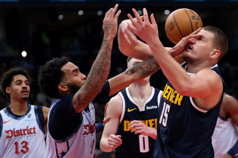 Nikola Jokic (#15), le pivot vedette des Denver Nuggets, subit une faute de la part de Justin Champagnie (#9), des Wizards, lors d'un match de saison régulière de NBA, le 7 décembre 2024 à Washington DC