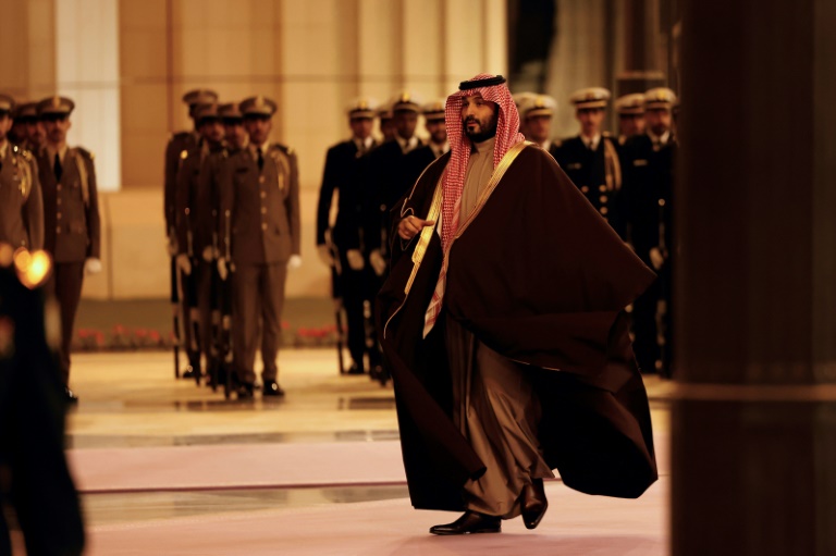 Le prince héritier d'Arabie saoudite Mohammed ben Salmane marche pour accueillir le président français (non photographié) avant leur rencontre à Riyad, le 2 décembre 2024