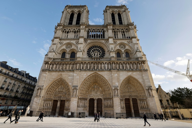 Des piétons passent devant la cathédrale Notre-Dame de Paris avant sa réouverture officielle, le 7 décembre 2024 à Paris