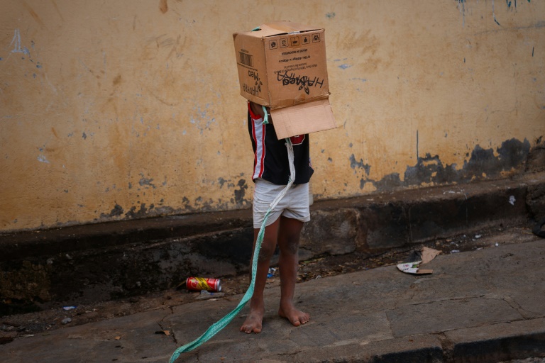 Un enfant porte un carton sur sa tête, dans un quartier dévasté de Mamoudzou, à Mayotte, le 20 décembre 2024, après le passage du cyclone meurtrier Chido