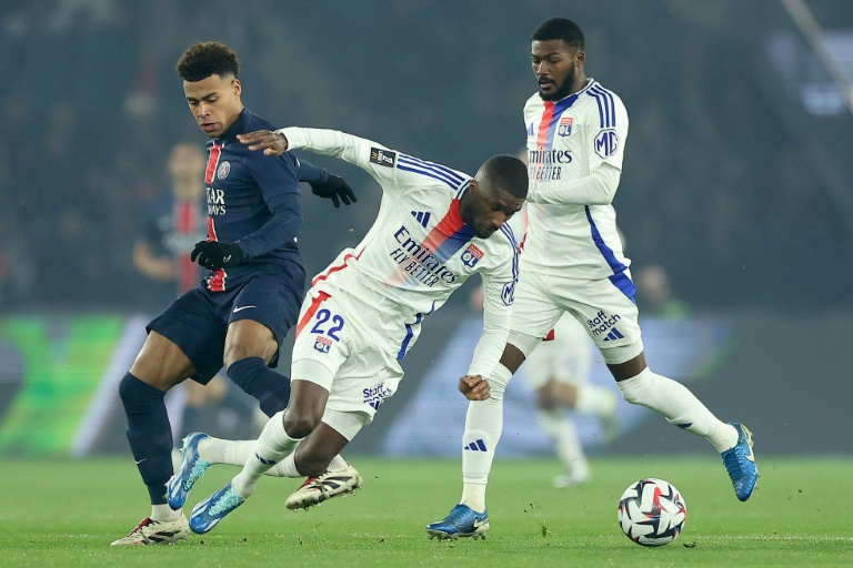 Le joueur du Paris Saint-Germain Desiré Doué (à gauche) lors du match de championnat de France contre l'Olympique lyonnais au Parc des princes le 15 décembre 2024.