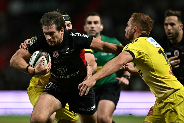 Le centre de Toulouse Pierre-Louis Barassi (noir) échappe au placage de l'ouvreur de La Rochelle Ihaia West (droite) lors d'un match de Top 14, le 15 septembre 2024