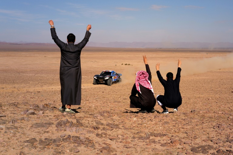 Des spectateurs saluent le passage du pilote sud-africain Brian Baragwanath lors de la 6e étape du Dakar-2025 entre Haïl et Al Duwadimi (Arabie saoudite), le 11 janvier 2025