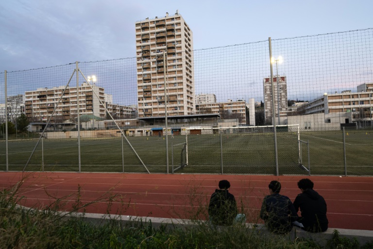 Des enfants assis devant un terrain de foot de la Busserine à Marseille le 24 janvier 2025