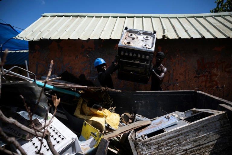 Des habitants nettoient les ruelles dans un bidonville détruit par le cyclone Chido dans la ville de Mamoudzou, le 31 décembre 2024