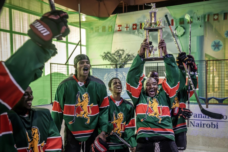 Des joueurs seniors de l'équipe nationale kenyane de hockey sur glace célèbrent leur victoire en recevant un trophée après un championnat amical à la patinoire Panari à Nairobi, le 24 janvier 2025