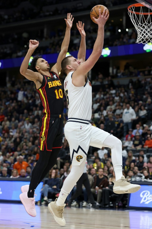 Nikola Jokic (Denver Nuggets) devant Zaccharie Risacher (Atlanta Hawks) à Denver le 1er janvier 2025.