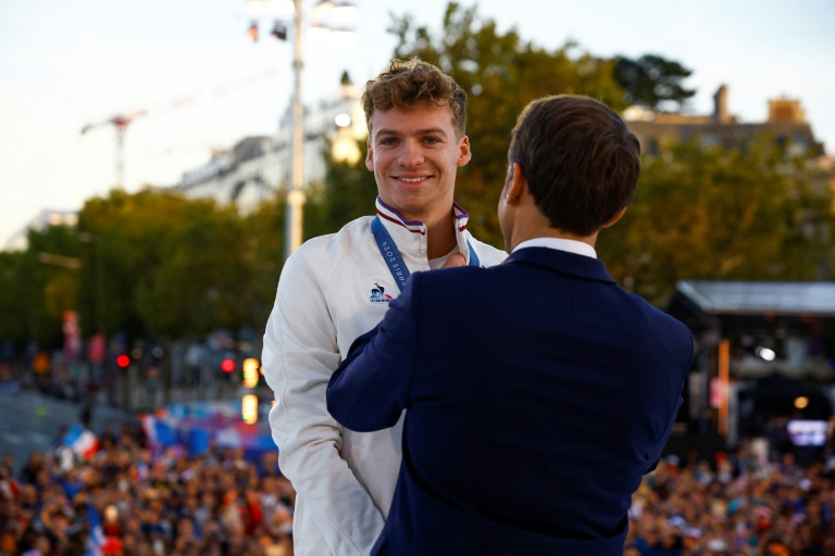 Le président Emmanuel Macron décore le nageur Léon Marchand, quadruple champion olympique, de la légion d'honneur, le 14 septembre 2024 lors d'une cérémonie à Paris